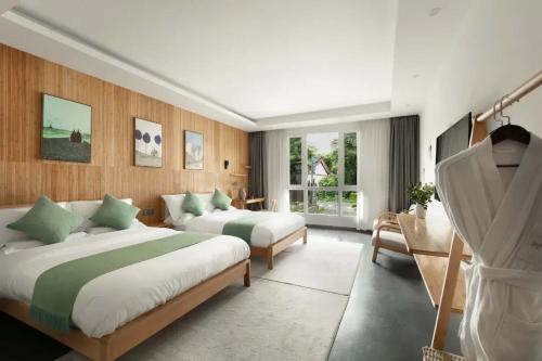 a large bedroom with two beds and a window at Tengchong Nan Su Gu Li Hot Spring EnjoyLife Family Resort (Tengyue Culture Plaza Branch) in Tengchong