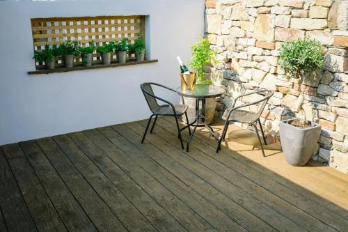 a patio with a table and chairs and a stone wall at 1863 Restaurant with Rooms in Pooley Bridge
