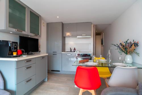 - une cuisine avec une table et des chaises rouges dans l'établissement Le Reflet du Port, à La Trinité-sur-Mer