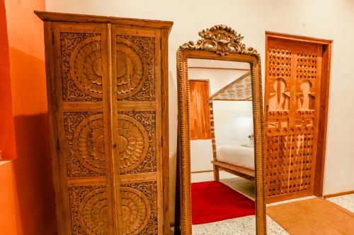 a wooden cabinet and a mirror in a room at La Marrocco Villas in Nusa Penida