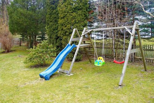 a playground with a slide and a swing set at Haus "Belvidere" in Elend