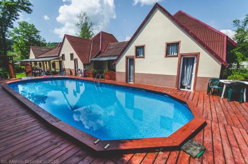 a large swimming pool on a wooden deck with a house at O.W. Blue Cafe in Krościenko
