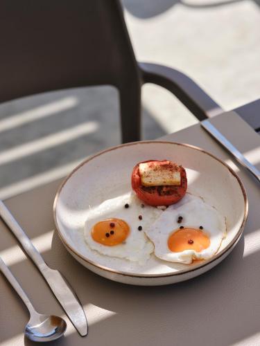 Gastouri奥罗斯海滩度假酒店的桌上放两个炒鸡蛋的盘子
