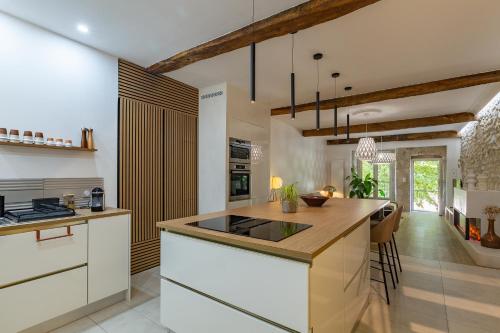 une cuisine avec des armoires blanches et un comptoir dans l'établissement Loft Aux Portes Du Vercors, à Pont-en-Royans