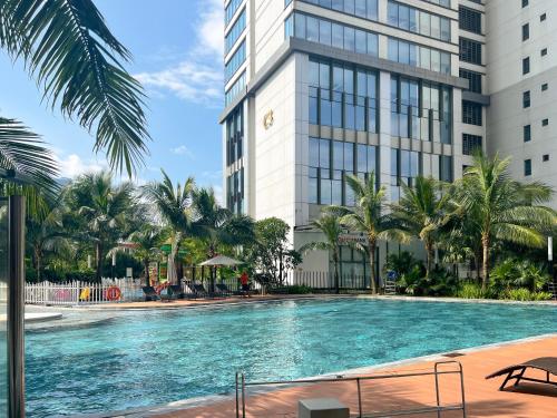 a swimming pool in front of a tall building at Tami Homes - Vinhomes D'Capitale Executive Apartment in Hanoi