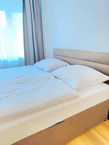 a bed with a box in front of a window at Riverside Apartment Praha in Prague