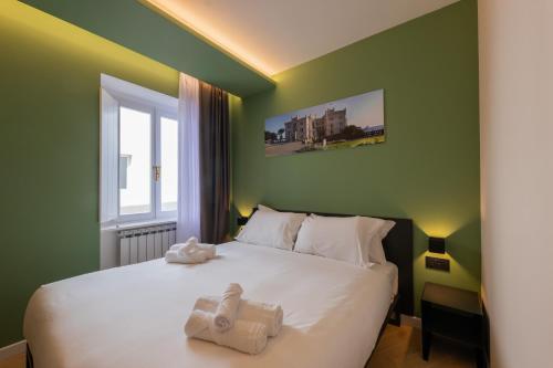 a green bedroom with a bed with towels on it at Luna Stay in Trieste