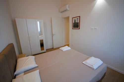a bedroom with a bed and a white wall at Altichiero 105 in Padova
