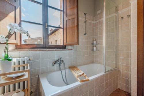 une salle de bain avec une baignoire et une fenêtre dans l'établissement Nel cuore della Toscana con piscina, à Asciano