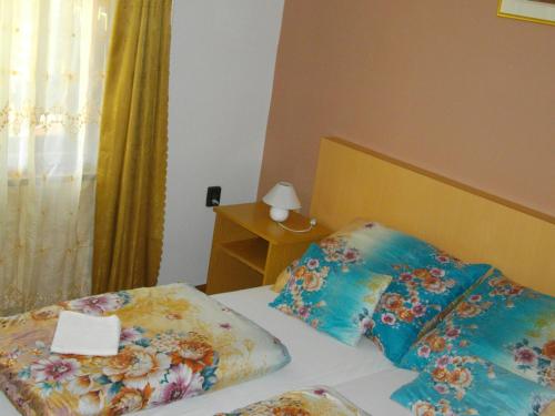 a bed with two pillows and a sign on it at Petra Vendégház in Bük