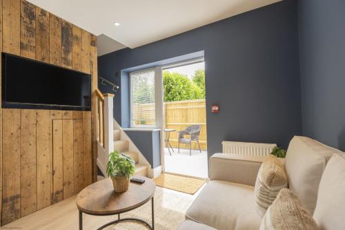 a living room with a couch and a tv at Bell House Oxford - The Noke in Oxford