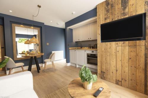 a kitchen and living room with a tv on a wall at Bell House Oxford - The Noke in Oxford