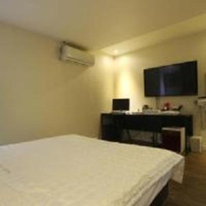 a bedroom with a white bed and a desk at Geoje MVG Motel in Geoje 