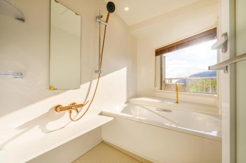 a bathroom with a sink and a window at KAMENOI HOTEL Atami in Atami