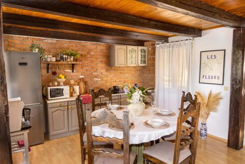 a kitchen and dining room with a table and chairs at Hilltop House. in Erdut