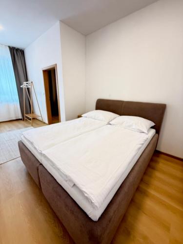 a bedroom with a large bed with white sheets at Riverside Apartment Praha in Prague
