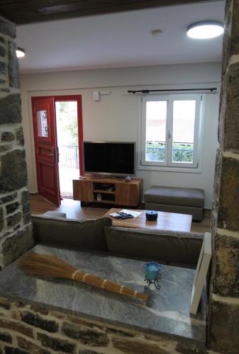a living room with a couch and a television at Rodonas-Apartments in Volissos