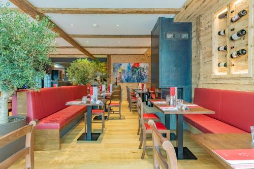a restaurant with red booths and tables and chairs at Hotel Piz St. Moritz in St. Moritz