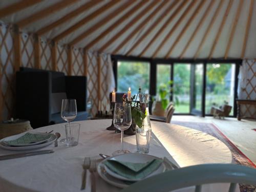 a table with a white table cloth and glasses on it at Harresø Haves Jurt in Give