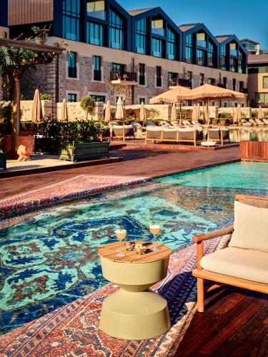Una piscina con un inodoro y una silla al lado de una piscina. en Aliée Istanbul - A Paris Society Collection Hotel, en Estambul