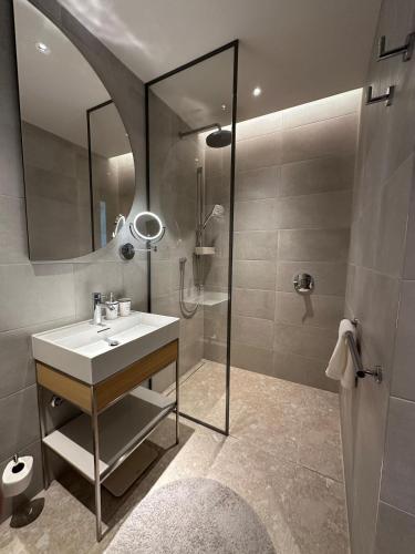 a bathroom with a sink and a shower with a mirror at Boka Place Home Thea in Tivat