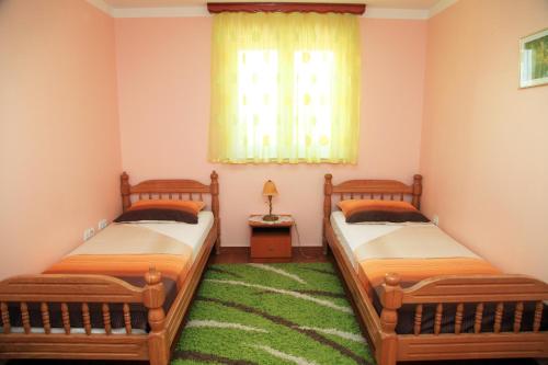 two twin beds in a room with a window at Apartments Hari Tisno in Tisno