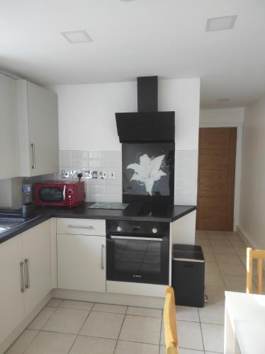 a kitchen with a stove top oven in a room at Cosy Private Home in London with Garden in London