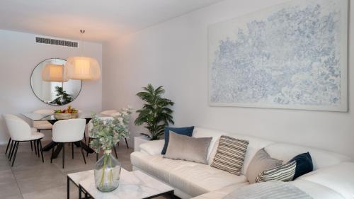 salon z białą kanapą i stołem w obiekcie VACATION MARBELLA I Via Celere, Huge Terrace, Brand New Complex, Close to the Beach, Marbella Center w Marbelli