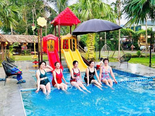 a group of women sitting in the water in a swimming pool at Thanh Xuân Ecolodge in Ðào Lãng