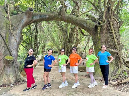 a group of women standing in front of a tree at Thanh Xuân Ecolodge in Ðào Lãng
