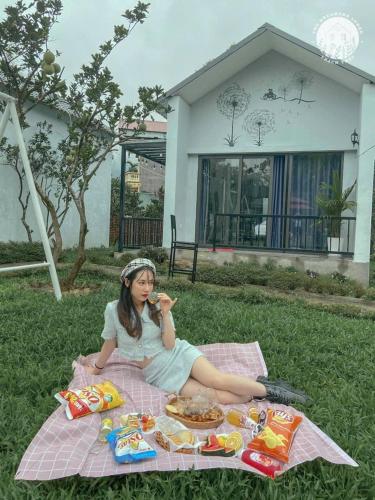a young girl sitting on a picnic blanket at Thanh Xuân Ecolodge in Ðào Lãng
