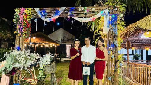 a man and three women standing in front of an arch at Thanh Xuân Ecolodge in Ðào Lãng
