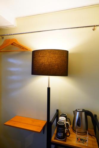 a lamp sitting on a table next to a bed at Sunset View Ridge Residences in Baguio
