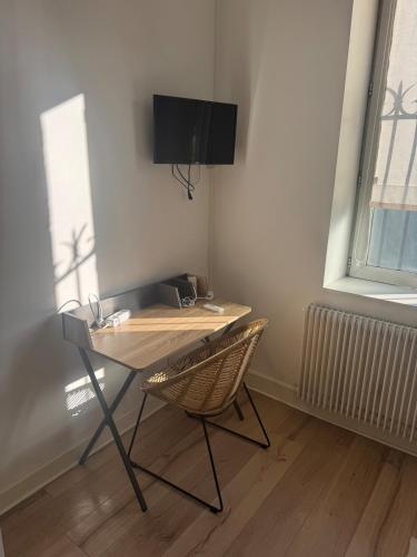 a desk in a room with a chair and a television at Charming little Bagatelle studio in Talence