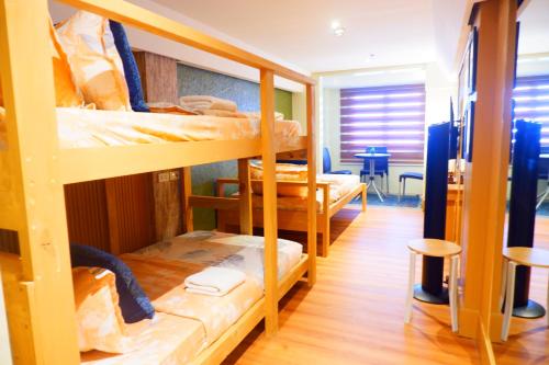 a room with three bunk beds and a table at Sunset View Ridge Residences in Baguio