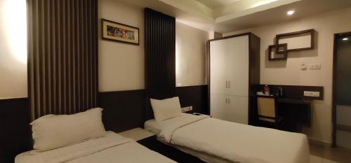 a hotel room with two beds and a mirror at Hotel Shiny Villa in Rānchī
