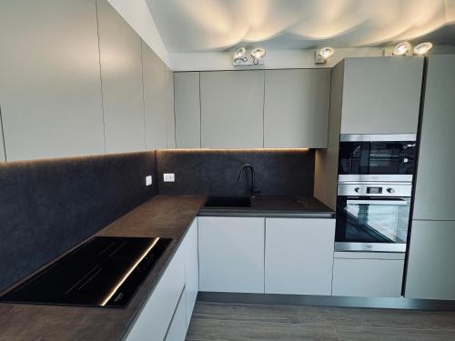 a kitchen with white cabinets and a sink at Residenza esclusiva appena costruita in Imola