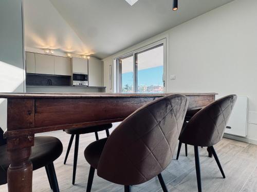 a kitchen with a wooden bar with two chairs at Residenza esclusiva appena costruita in Imola