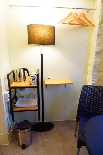 a lamp in a room with a table and a shelf at Sunset View Ridge Residences in Baguio