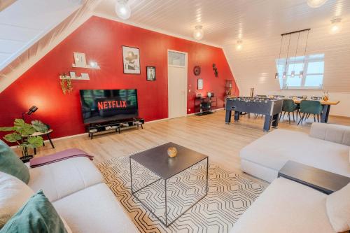 a living room with a red wall and a pool table at Rheinsteig Chalét Bendorf in Bendorf