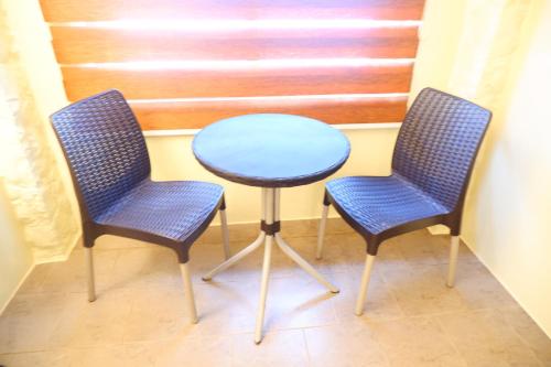 two blue chairs and a table in a room at Sunset View Ridge Residences in Baguio
