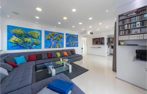 a living room with a blue couch and paintings on the wall at Amazing Home In Crikvenica in Crikvenica