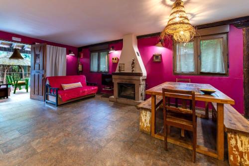a living room with pink walls and a fireplace at Apartamentos Rurales & Spa La Bárcena in Enterria