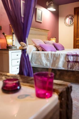 two beds in a room with purple curtains at Apartamentos Rurales & Spa La Bárcena in Enterria
