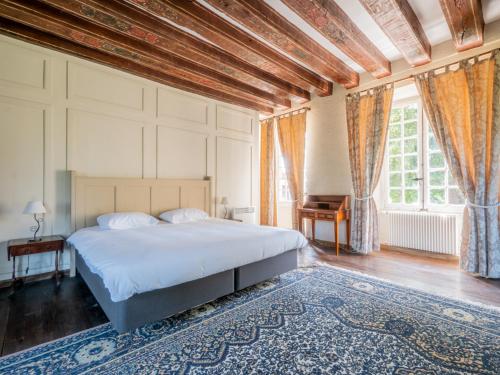 a bedroom with a bed and a table and a window at Manoir des Dryades & Annexes - 29 personnes in Pouligny-Notre-Dame