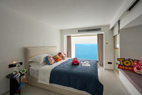 a bedroom with a bed with a view of the ocean at Shenzhen GuanHu Secret Wild Reef Seaview Hotel in Shenzhen