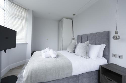 a white bedroom with a large bed with white pillows at Bell House Oxford - The Punt in Oxford