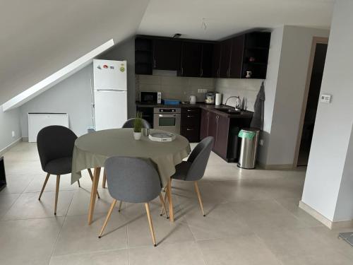 a kitchen with a table and chairs in a room at Tündérrózsa Vendégház Pásztó in Pásztó