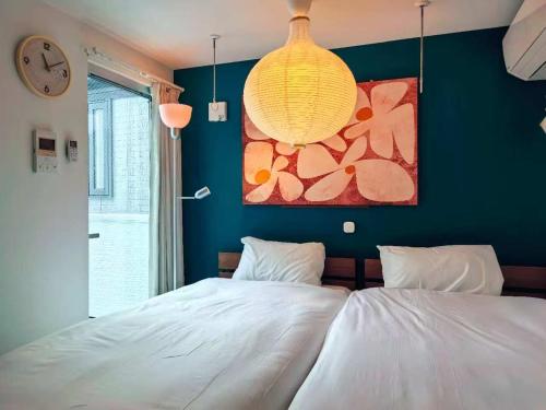 a bedroom with a large white bed and a clock at Mossy Nest Negishi I 鶯谷駅徒歩7分 上野徒歩圏内 in Tokyo