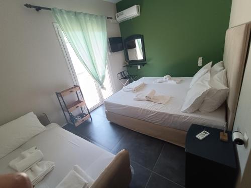 a hotel room with two beds and a window at Pool me up 22 apartment in Megali Ammos
